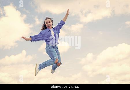 gaie jeune fille sautant haut. saut d'enfant en plein air. mode et beauté d'enfant. sens de la liberté. portrait d'une jeune fille énergique. concept de l'avenir Banque D'Images