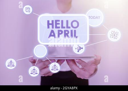 Légende conceptuelle Hello April, Business Idea expression de bienvenue utilisée lors de l'accueil du mois d'avril Lady en uniforme Standing Tablet Sho Banque D'Images