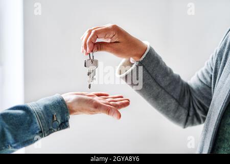 Agent immobilier méconnaissable remettant les clés de l'appartement au client. Banque D'Images