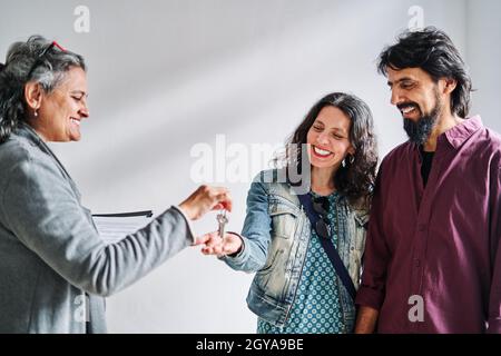 Agent immobilier remettant les clés de l'appartement aux clients. Banque D'Images