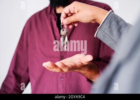 Agent immobilier méconnaissable remettant les clés de l'appartement au client. Banque D'Images