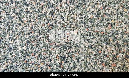 Surface en béton gris avec éclats de marbre multicolores.Premier plan.Éclats de marbre gris foncé.Mur, façade ornée de copeaux de marbre. Banque D'Images