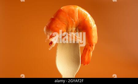 Un grand roi cuit des crevettes dans l'évier sur une fourche en bois sur un fond brun. Infrastructure des crustacés de la décapodes, mangeant la charogne. Mer del Banque D'Images