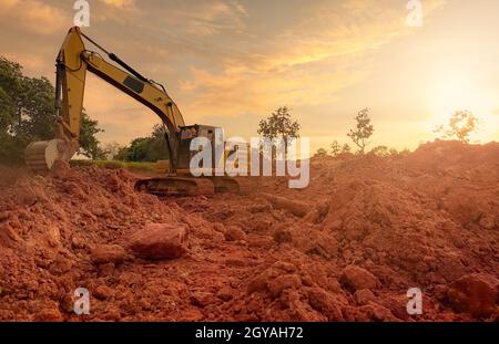 Pelle rétro travaillant en creusant le sol sur le chantier. Les dents du godet de la pelle rétro creusent le sol. Pelle hydraulique creusant sur terre. Machine d'excavation. Earthmovin Banque D'Images