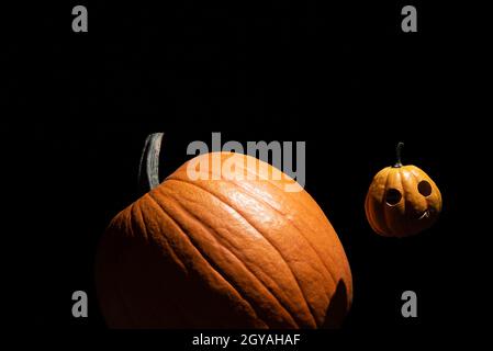 Petits orbites de citrouille d'Halloween dans l'espace comme une lune autour de la grande planète une.Arrière-plan noir.Rectangle avec espace de copie.Concept minimal. Banque D'Images