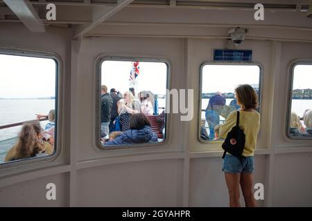 Une femme seule et âgée portant un short voit d'autres passagers à bord du Mersey Ferry, Snowdrow lorsqu'il traverse la rivière Banque D'Images