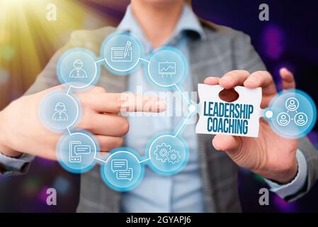 Affiche textuelle montrant le coaching de leadership, mot écrit sur le processus individualisé qui construit un leader est la capacité Business Femme pointant Jigsaw Puzz Banque D'Images