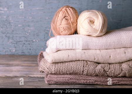 Vêtements de tricot et de fils sur fond de bois Banque D'Images