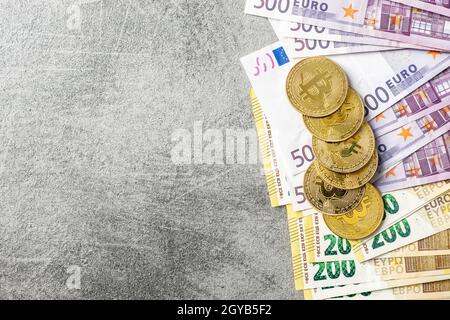 Billets et bitcoins en euros. Pièces d'une crypto-monnaie. Vue de dessus. Banque D'Images