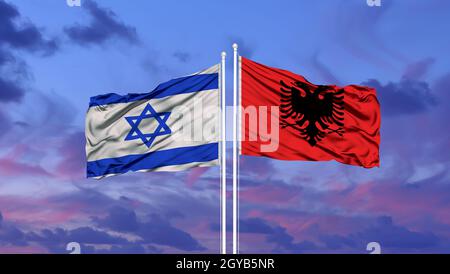 Israël et l'Albanie deux drapeaux sur les mâts et bleu nuageux ciel Banque D'Images