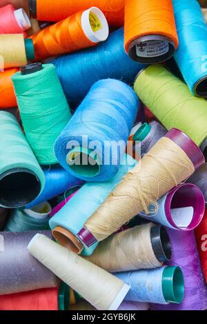 Bobines orange, bleu clair, bleu ciel, marron clair, blanc,fil violet, rouge et violet clair Banque D'Images