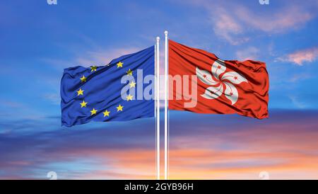 Union européenne et Hong Kong deux drapeaux sur les mâts de drapeaux et ciel bleu nuageux Banque D'Images