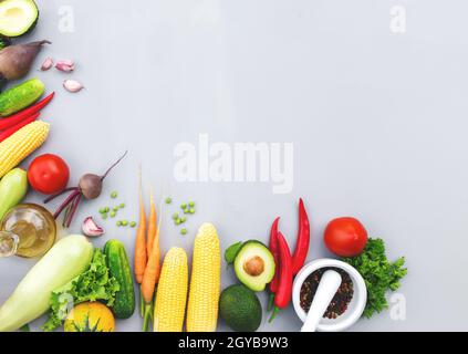 Plat avec différents légumes, fruits, baies, noix, épices, herbes, huile d'olive. Copier la zone d'espace pour du texte. Légumes sur fond de béton gris Banque D'Images