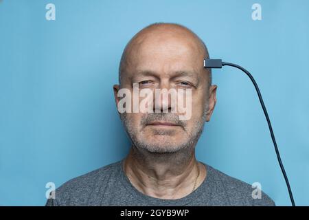 Un homme avec le cerveau connecté par un câble USB Banque D'Images