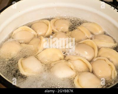 Les boulettes de la pâte avec de la viande sont bouillies dans de l'eau bouillante.Photo de nourriture.Le plat culinaire.Boulettes ukrainiennes.Feuille de Laurier.Boulettes dans une plaque.BA Banque D'Images