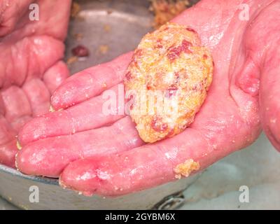 Côtelettes de viande crue dans les mains du cuisinier.Photo de nourriture.Plat à viande.Préparation des aliments.Cuisine maison.Recette.Viande hachée crue.Viande de poulet.Cutlets.Cuire. Banque D'Images