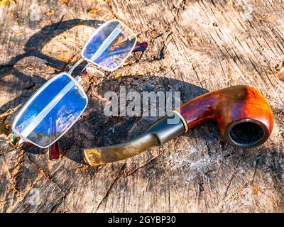 Pipe à fumer pour le tabac et les verres sur une table en bois.Tuyau en bois pour fumer du tabac.Outil fumeur.Mauvaises habitudes.Dépendance à la nicotine.Nicotine dans l'ic Banque D'Images