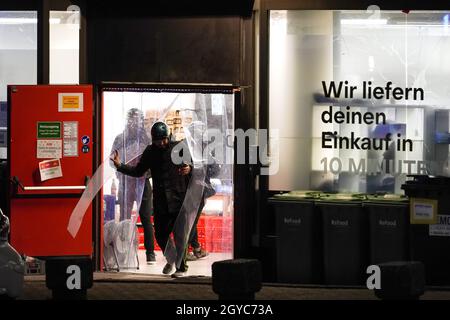 Chauffeur/pilote de livraison devant l'entrepôt de livraison du service de livraison Gorillas à Dortmund, Allemagne.Le service de livraison promet de livrer des provisions en moins de 10 minutes en vélo.Lieferfahrer/Rider vor dem Auslieferungslager des Lieferdienstes Gorillas à Dortmund.Der Lieferdienst verspricht, Lebensmittel in unter 10 Minuten mit dem Fahrrad zu liefern. Banque D'Images