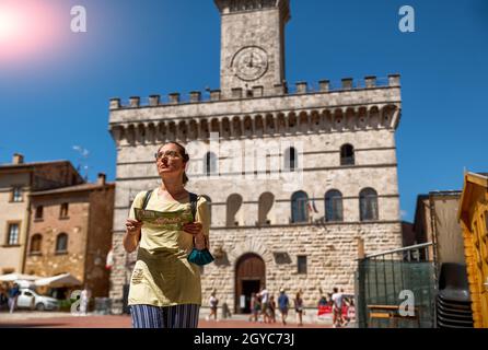 Montepulciano, Toscane, Italie.Août 2020.Dans la place de l'hôtel de ville, une femme caucasienne avec une carte touristique regarde autour de, l'accent sélectif sur la femme. Banque D'Images