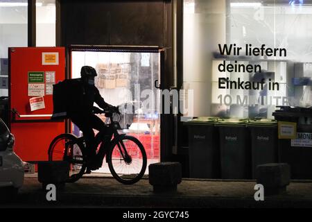 Chauffeur/pilote de livraison devant l'entrepôt de livraison du service de livraison Gorillas à Dortmund, Allemagne.Le service de livraison promet de livrer des provisions en moins de 10 minutes en vélo.Lieferfahrer/Rider vor dem Auslieferungslager des Lieferdienstes Gorillas à Dortmund.Der Lieferdienst verspricht, Lebensmittel in unter 10 Minuten mit dem Fahrrad zu liefern. Banque D'Images