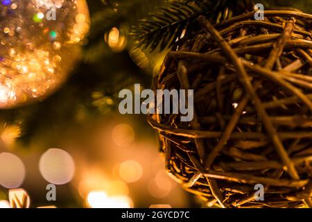 Photo macro d'une boule de Noël à partir de bâtons sur fond de feuilles avec des lumières de bokeh et une boule vivivivile Banque D'Images