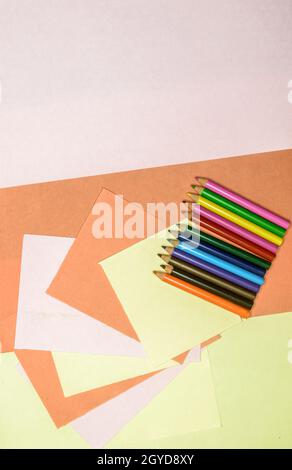 Crayons de couleur sur papier artisanal coloré. Loisirs d'art et d'artisanat, conception, concepts de fond. Vue du dessus de la table. Pose à plat. Banque D'Images