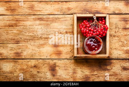 Pot en verre avec confiture et baies de viburnum fraîches Banque D'Images