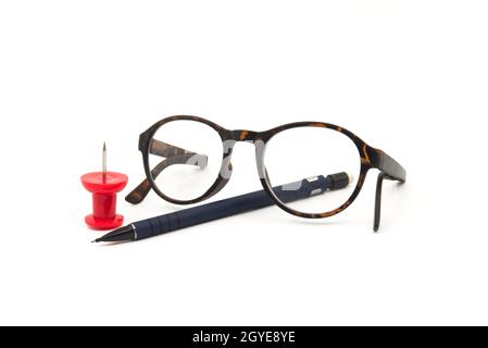 Lunettes de lecture avec cadres de tortoiseshell, stylo et pouce rouge coloré collant sur un fond blanc avec espace de copie dans une vie d'affaires encore Banque D'Images