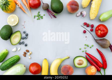 Plat avec différents aliments, légumes biologiques, fruits bio, baies, noix, épices, herbes. Copier la zone d'espace pour du texte. Légumes sur fond de béton gris Banque D'Images