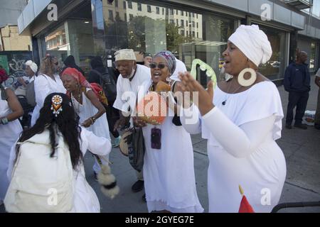 Le groupe participe à une marche de guérison africaine autour de Harlem pendant la journée du festival du patrimoine africain, qui s'est dirigé vers la 125e rue jusqu'au bâtiment d'État de l'État de New York Adam Clayton Powell jusqu'à African Square. Banque D'Images