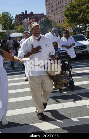 Le groupe participe à une marche de guérison africaine autour de Harlem pendant la journée du festival du patrimoine africain, qui s'est dirigé vers la 125e rue jusqu'au bâtiment d'État de l'État de New York Adam Clayton Powell jusqu'à African Square. Banque D'Images