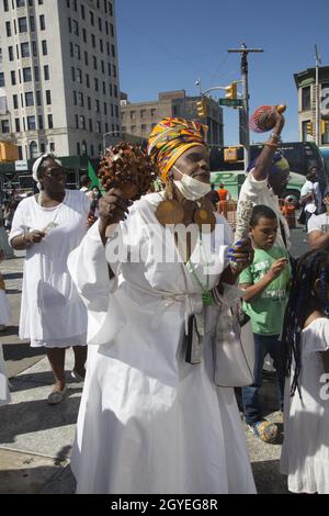 Le groupe participe à une marche de guérison africaine autour de Harlem pendant la journée du festival du patrimoine africain ici vu par la 125e rue au bâtiment d'état Adam Clayton Powell de l'African Square. Banque D'Images