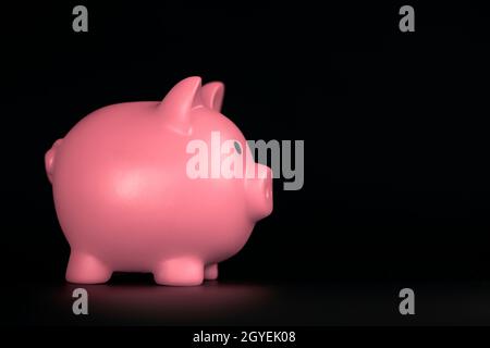 Pink Piggy Bank horizontal sur fond noir avec espace de copie, affaires, économies et ombres de concept financier Banque D'Images