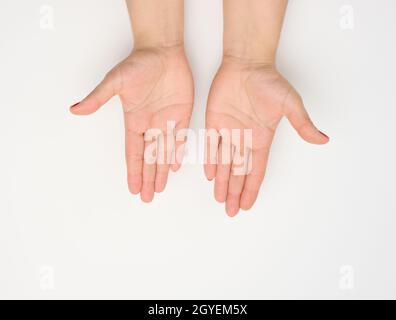 deux mains femelles avec ongles peints en rouge dans une pose de prière sur fond blanc, vue de dessus Banque D'Images