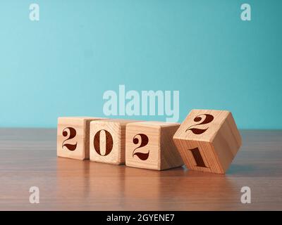 Des cubes en bois à retourner avec les numéros de l'année 2021 et 2022, concept du nouvel an, période de Noël saisonnière Banque D'Images