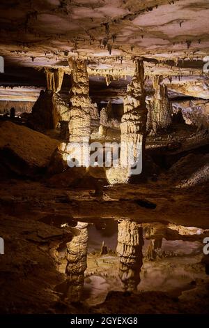 Paire majestueuse de stalagmites reflétant dans l'eau cristalline d'une grotte profonde Banque D'Images
