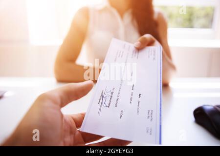 Remise du chèque de paie à l'employé. Chèque de salaire Banque D'Images