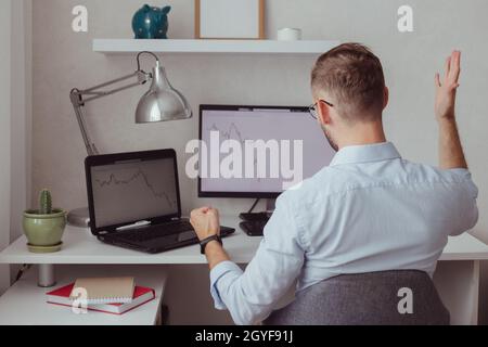 Homme en colère investisseur-Trader devant des moniteurs avec des graphiques. Correction boursière. Chute de la crypto-monnaie. Échec financier. Marché baissier. Forex Banque D'Images