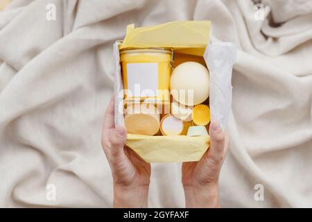 Ensemble de boîtes de soins écologiques pour femmes. Sel de bain, gommage, savon à la main, éponge à laver sur fond textile. Vue de dessus Banque D'Images