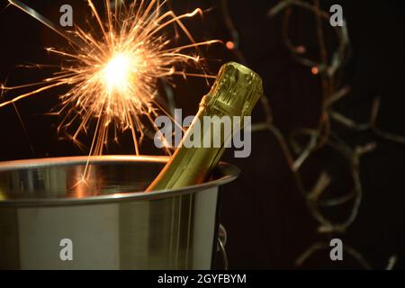 Bouteille de champagne avec feu bengale. Concept de la nouvelle année Banque D'Images