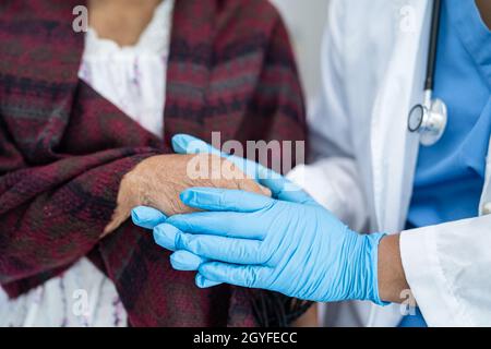 Médecin tenant des mains en contact asiatique senior ou âgée vieille femme patiente avec amour, soins, aide, encourager et empathie à l'hôpital de soins infirmiers, Banque D'Images