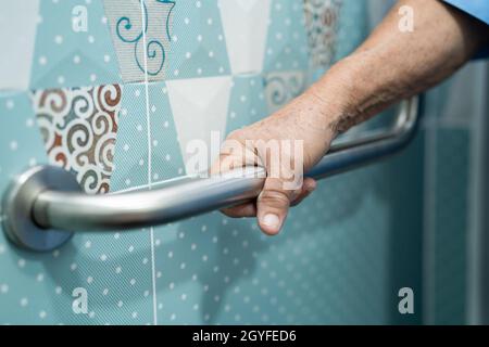 Asiatique senior ou âgée vieille femme patiente utiliser toilettes salle de bains poignée de sécurité dans la salle d'hôpital de soins infirmiers, sain solide concept médical. Banque D'Images