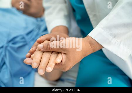 Médecin tenant des mains en contact asiatique senior ou âgée vieille femme patiente avec amour, soins, aide, encourager et empathie à l'hôpital de soins infirmiers, Banque D'Images