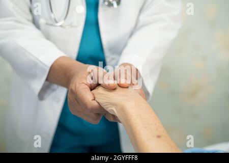 Médecin tenant des mains en contact asiatique senior ou âgée vieille femme patiente avec amour, soins, aide, encourager et empathie à l'hôpital de soins infirmiers, Banque D'Images