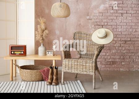 Intérieur de chambre élégante avec table, fauteuil en osier et écran pliant Banque D'Images