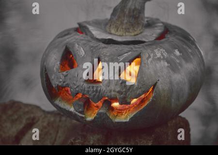 Halloween.Citrouille sur fond d'étang, elle brille, une flamme brûeuse brûle à l'intérieur Banque D'Images