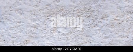 Mur peint en blanc très rugueux en pierres à gravats en gros plan Banque D'Images