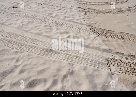Chenilles pour pneus 4x4 sillonnent les chenilles pour pneus sur fond de texture sable. Banque D'Images