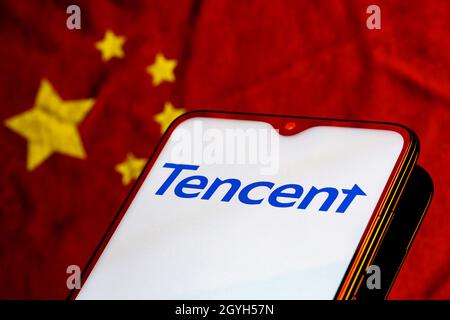 Smartphone avec le logo Tencent sur l'arrière-plan du drapeau chinois. Banque D'Images