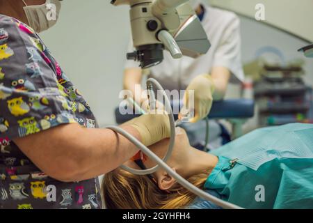 Traitement dentaire au microscope.Femme ayant des dents examinées chez les dentistes.Rendez-vous chez le dentiste. Style de vie, vie réelle Banque D'Images